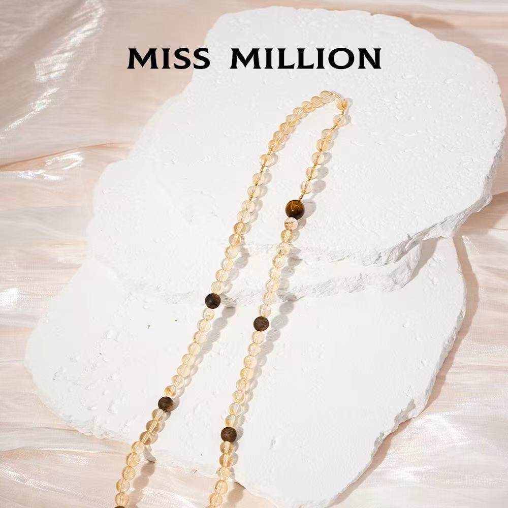 The necklace cleverly incorporates elements representing "RICH" and "POWERFUL"